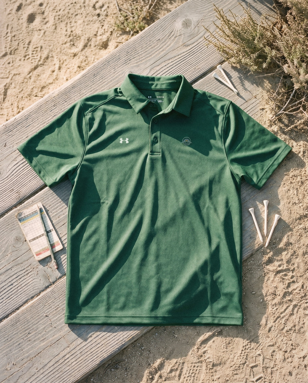 Forest green polo flat lay, embroidered emblem on the left chest
