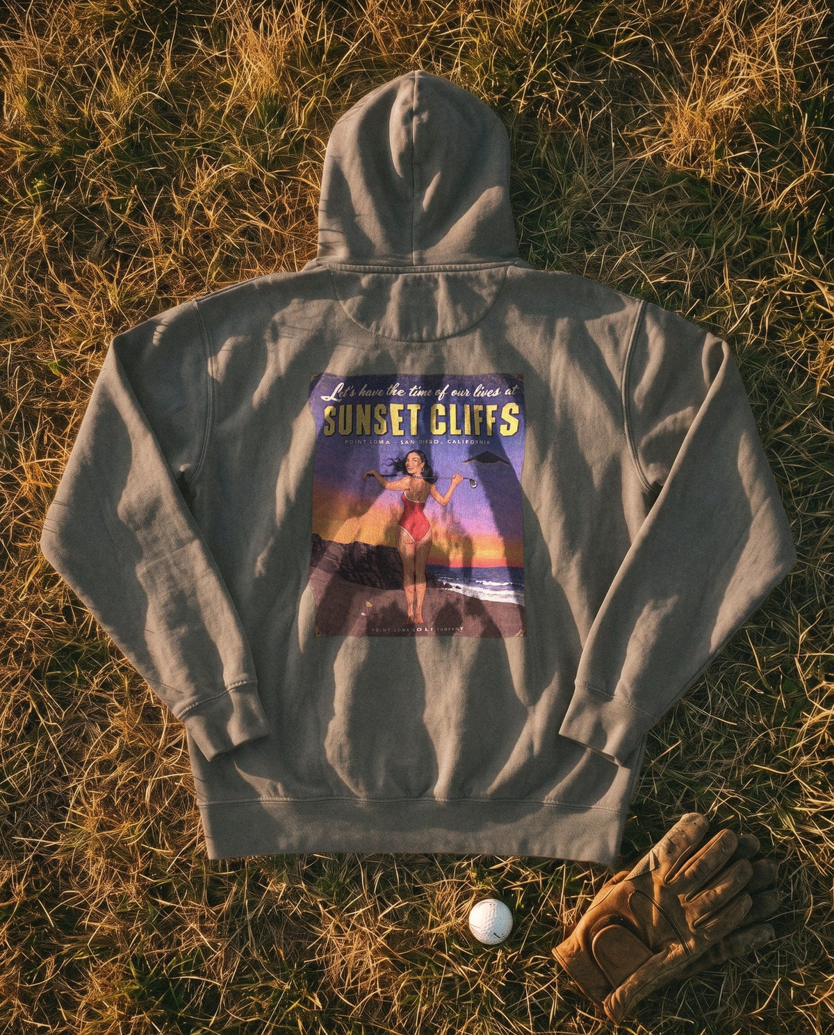 Pepper Flyover Hoodie flat lay, Sunset Cliffs dusk sign on the back